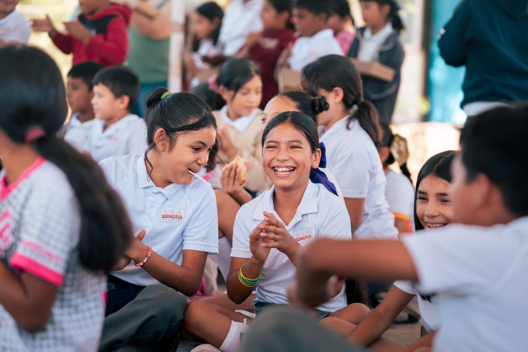 crowd of girls, focused on two smiling