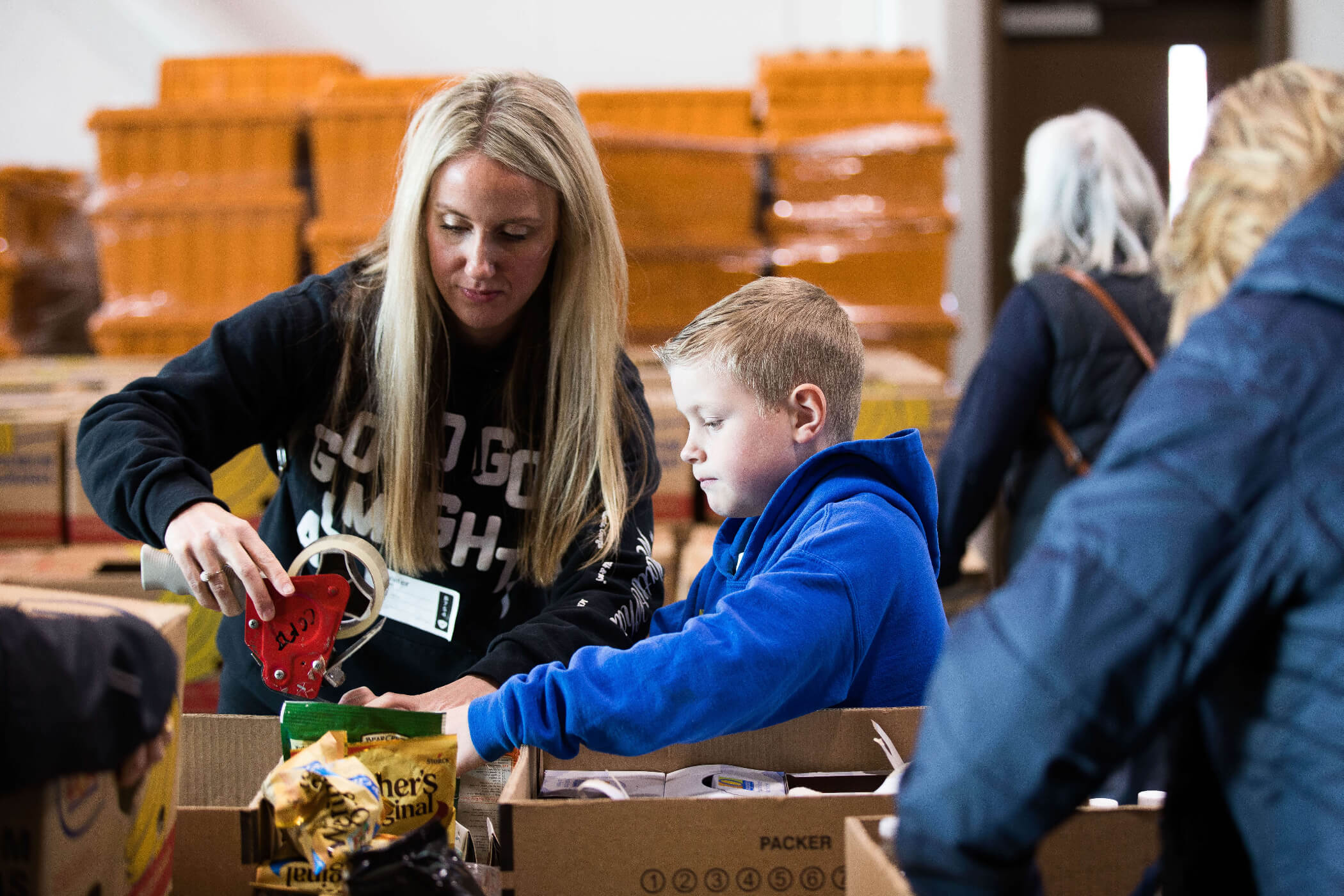woman and child packing food into boxes